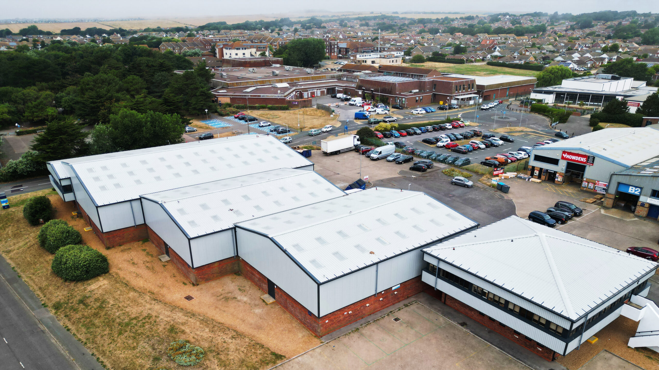 JLL Peacehaven commercial property roof and cladding refurbishment by Weatherproofing Advisors, with new insulation, rooflights, and Anthracite finishes.